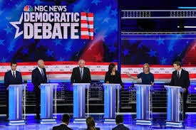 Presidential candidates stand at podiums at a democratic debate